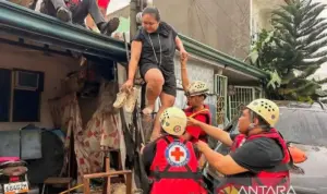Tim penyelamat mengevakuasi warga dari rumah mereka yang terendam banjir setelah hujan deras yang dipicu Topan Kalmaegi di Provinsi Cebu, Filipina
