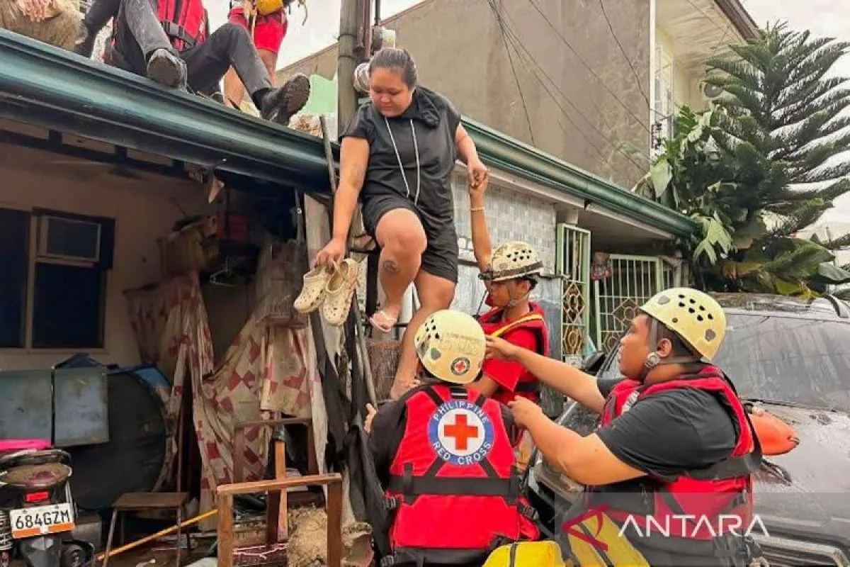 Tim penyelamat mengevakuasi warga dari rumah mereka yang terendam banjir setelah hujan deras yang dipicu Topan Kalmaegi di Provinsi Cebu, Filipina